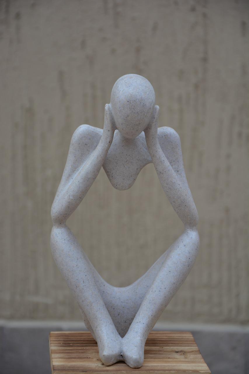 Escultura humana sin torso que se sostiene la cabeza