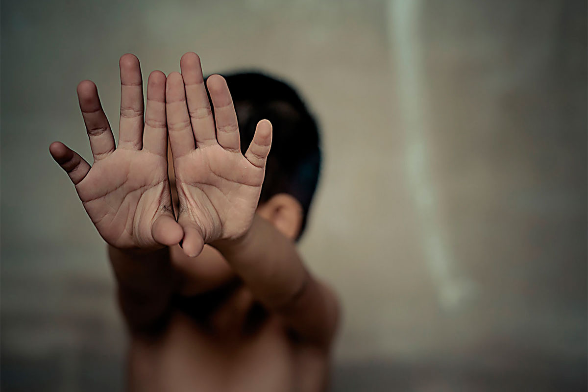 Niño tratando de detener algo con sus manos.